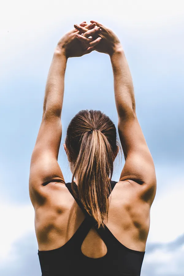 GLP-1-Weight-Loss-Injections-Treatment A toned woman seen from behind stretching her arms into the air. Get GLP-1 Weight Loss Injections from Healthy Aging Medical Centers of New Jersey in Northern New Jersey.