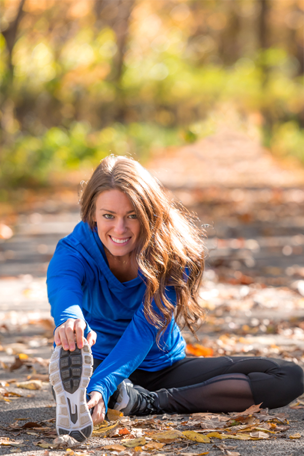 InBody-Composition-Scan Woman wearing athletic gear stetching on a leaf covered trail during day time. Schedule an InBody Composition Scan with Healthy Aging Medical Centers of New Jersey in Northern New Jersey.