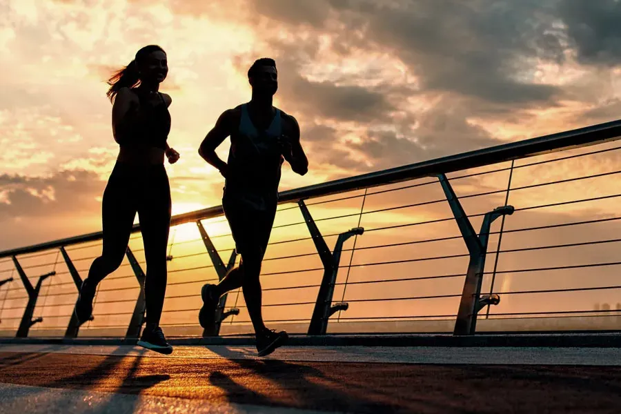 Lipo-Mino-Vitamin-Shot-Clinic A couple runs on a bridge at sunrise. Get Lipo-Mino vitamin shots for weight loss from Healthy Aging Medical Centers of New Jersey in Northern New Jersey.
