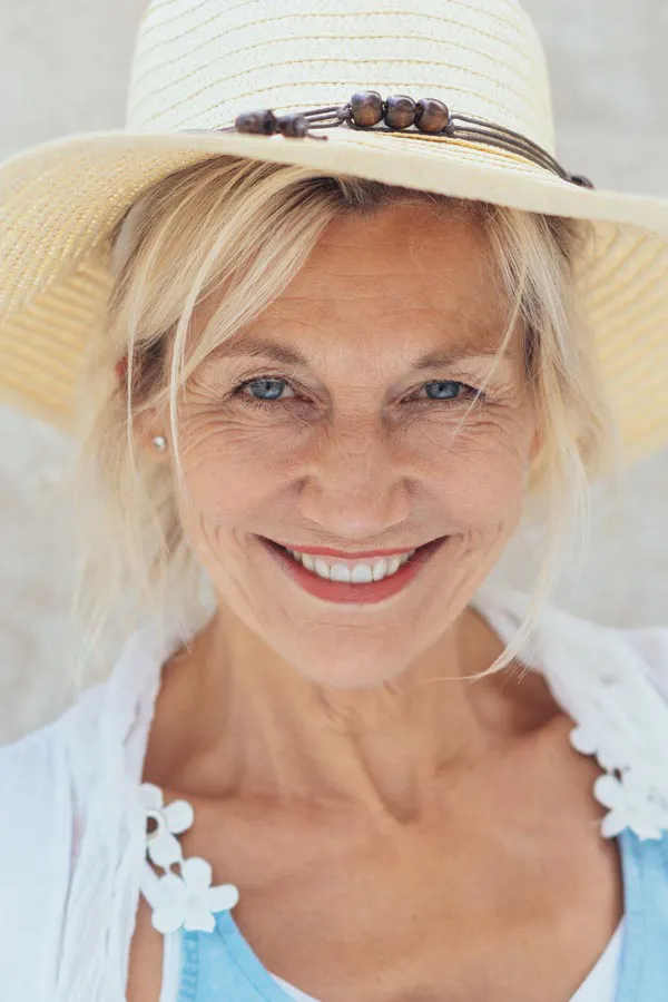 Menopause-Treatment A beautiful, smiling older woman with blonde hair and a sunhat, happy with menopause treatment from Healthy Aging Medical Centers of New Jersey in Northern New Jersey.