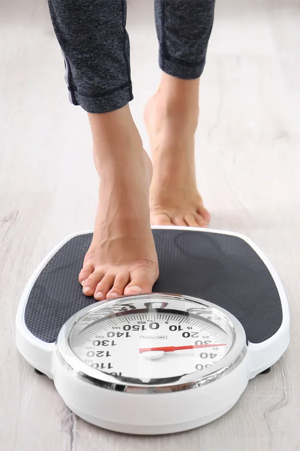 Obesity-Treatment Close up of feet stepping onto a scale. Receive expert functional medicine for obesity treatment by Healthy Aging Medical Centers of New Jersey in Northern New Jersey.