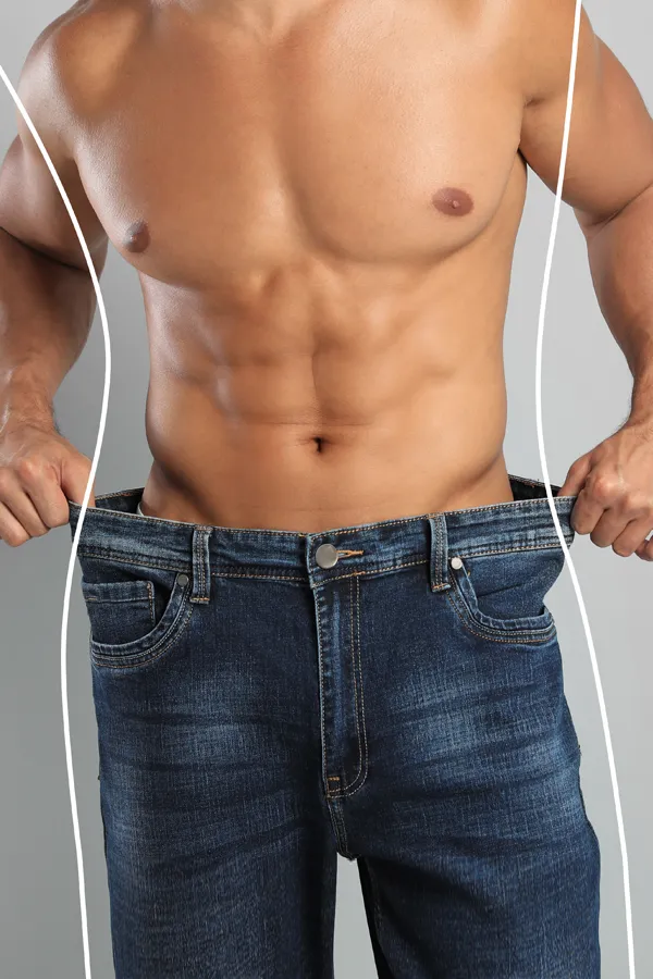 Semaglutide-Weight-Loss-Treatment A strong shirtless man in jeans holds the waistlines of his too-big jeans to show the success of semaglutide weight loss from Healthy Aging Medical Centers of New Jersey in Northern New Jersey.