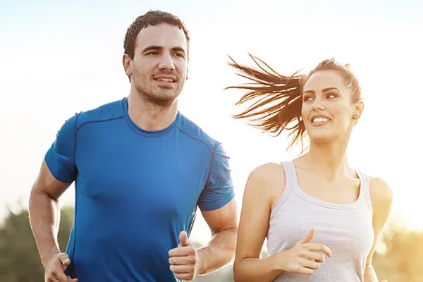 A couple happily jogging in the sunlight after receiving effective weight loss resistance care from Healthy Aging Medical Centers of New Jersey in Northern New Jersey.